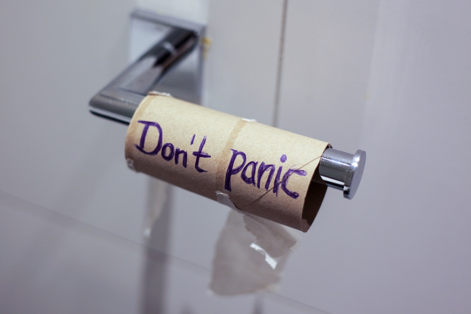 Photo of empty toilet roll with don't panic written on it.