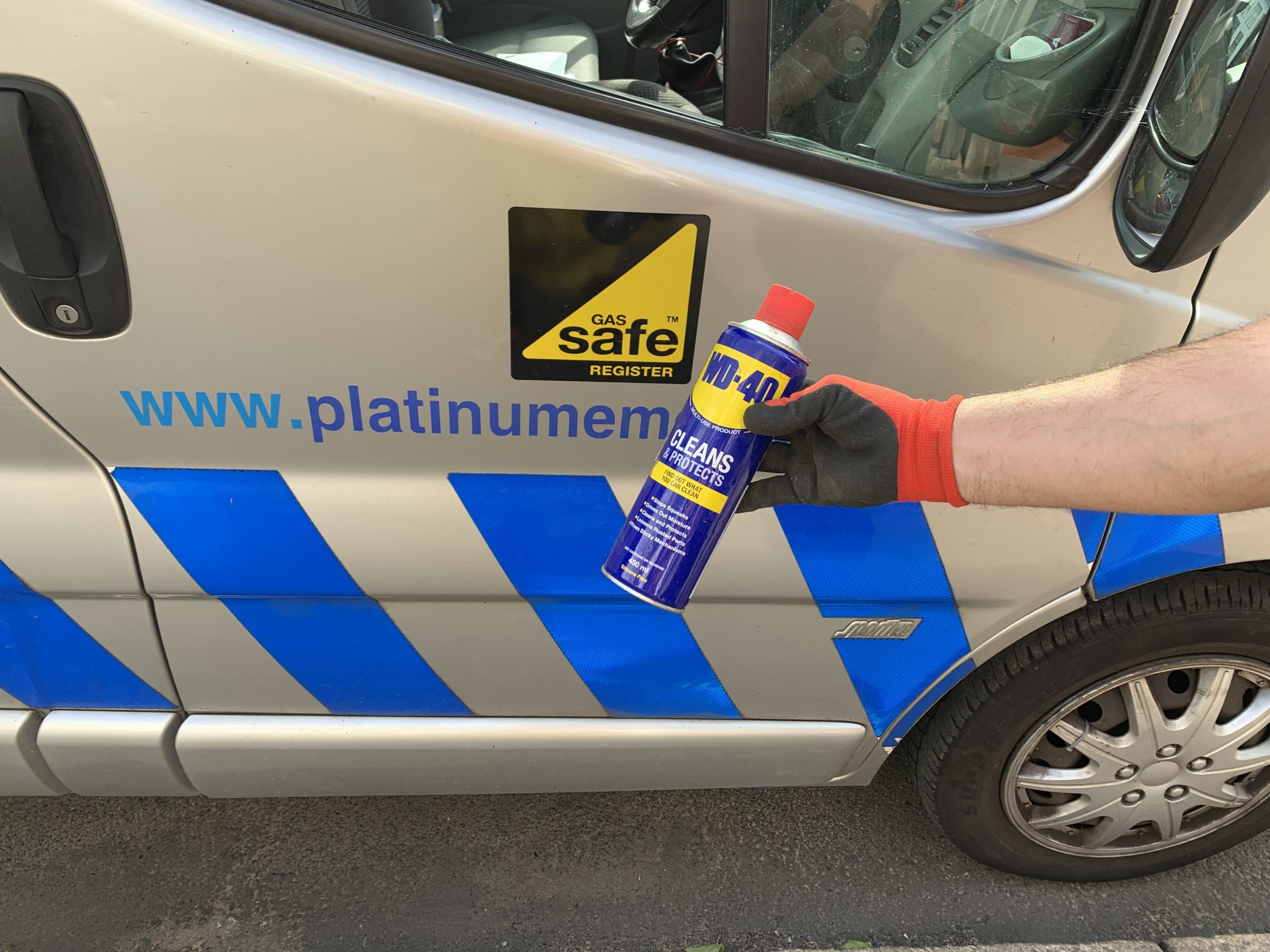 Photo with person holding can of WD40.  In the background is website www.platinumemergency.com