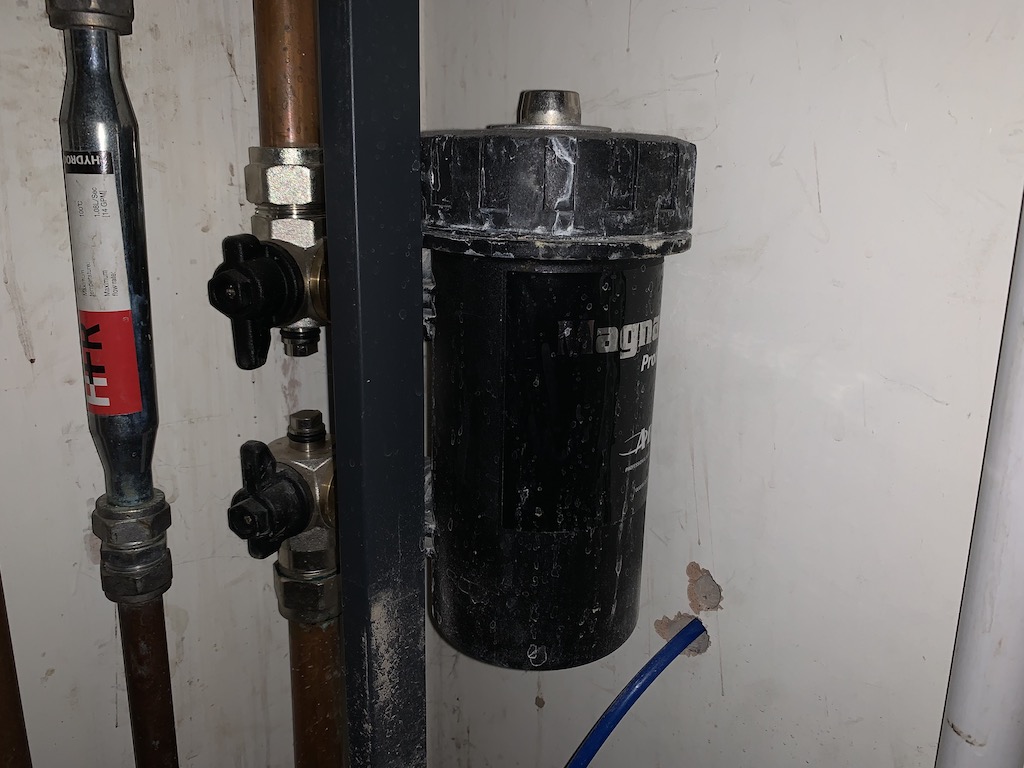 Photo showing a magnetic filter that is attached to a pipe for your boiler.